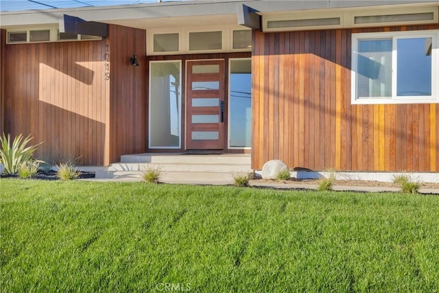 entrance to property featuring a lawn