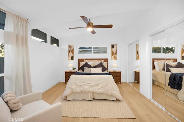 bedroom with baseboards, light wood-type flooring, a ceiling fan, and vaulted ceiling