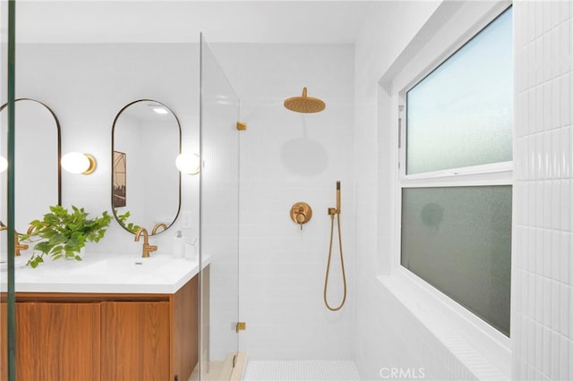 bathroom with vanity and a tile shower