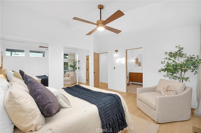 bedroom with ensuite bathroom, light wood finished floors, and ceiling fan