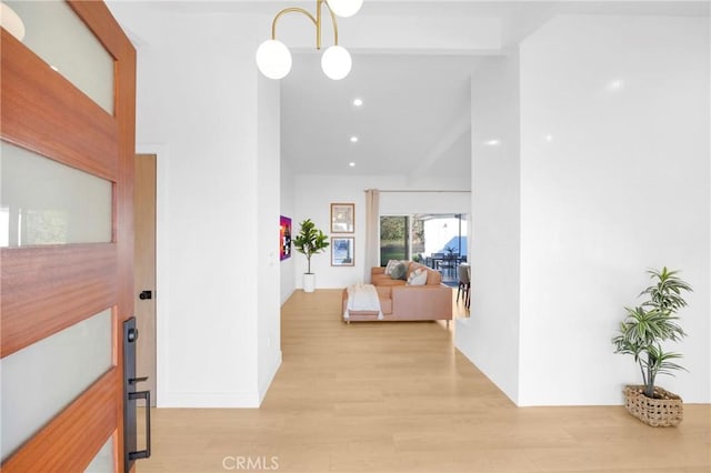 corridor featuring lofted ceiling, recessed lighting, and light wood-style floors