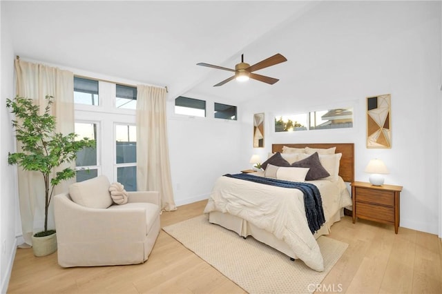 bedroom featuring lofted ceiling, wood finished floors, baseboards, and ceiling fan