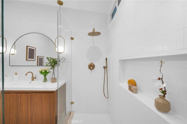 bathroom featuring tiled shower and vanity