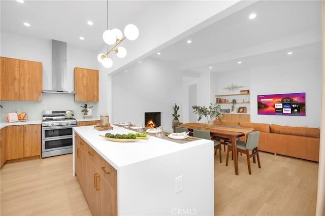 kitchen with double oven range, modern cabinets, wall chimney exhaust hood, and a center island