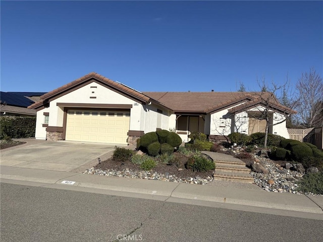 view of front of home with a tile roof, an attached garage, driveway, and stucco siding