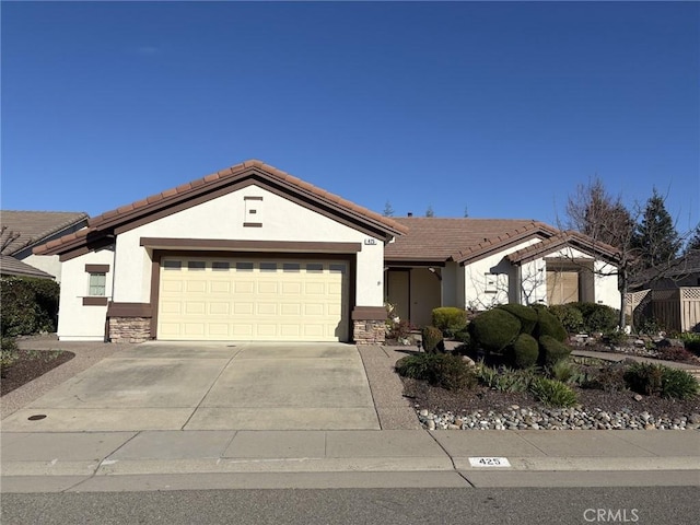 view of front of house with driveway, an attached garage, stucco siding, stone siding, and a tile roof