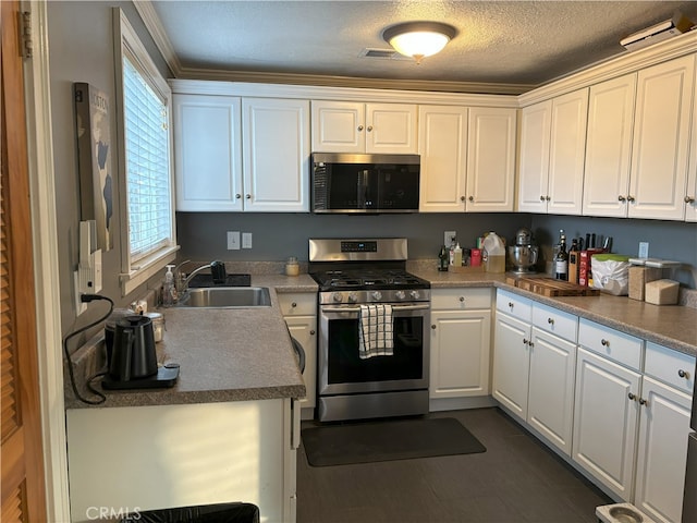 kitchen featuring white cabinets, appliances with stainless steel finishes, a textured ceiling, and a sink