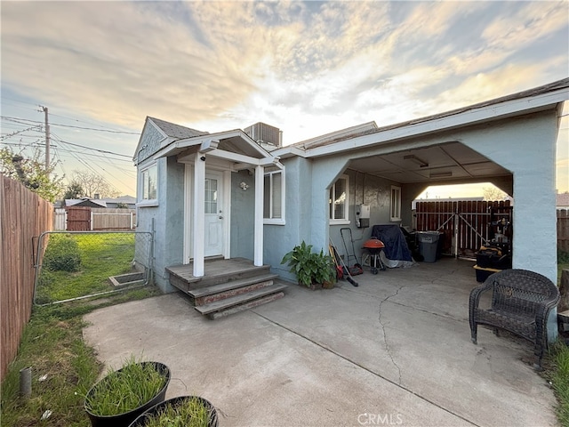 exterior space featuring a patio area, stucco siding, a fenced backyard, and a gate