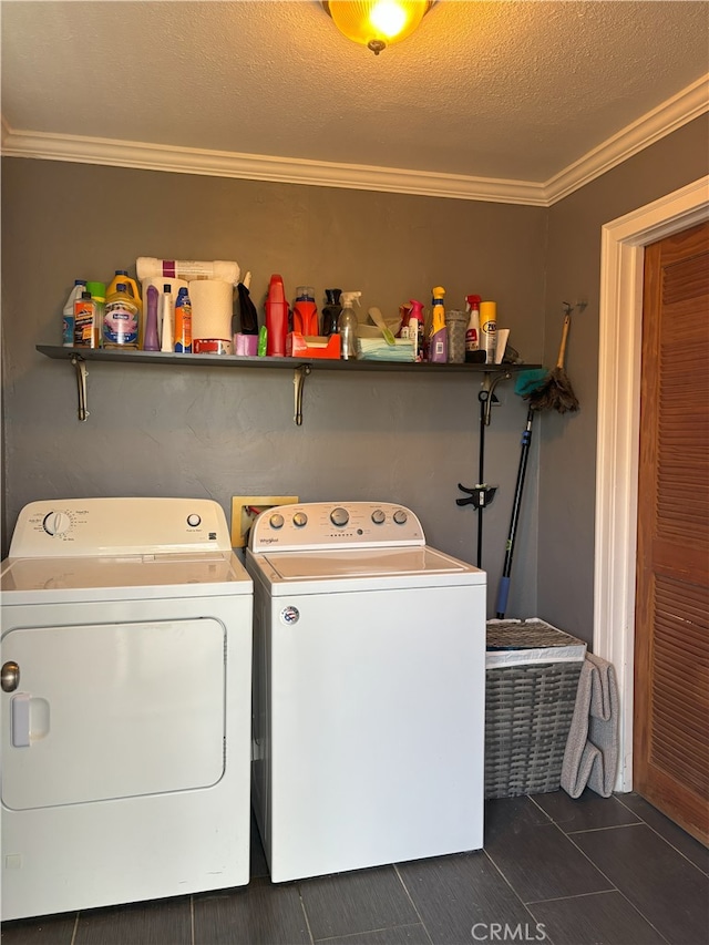 laundry area with a textured ceiling, separate washer and dryer, laundry area, and crown molding