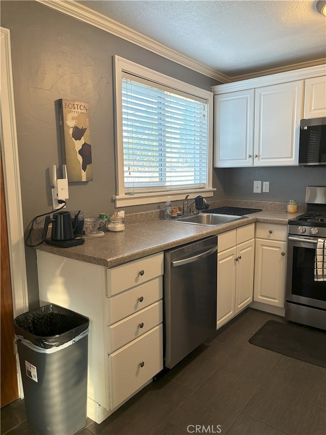 kitchen with a sink, stainless steel appliances, white cabinets, and ornamental molding