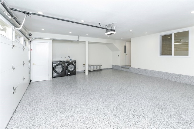 garage with a garage door opener and independent washer and dryer