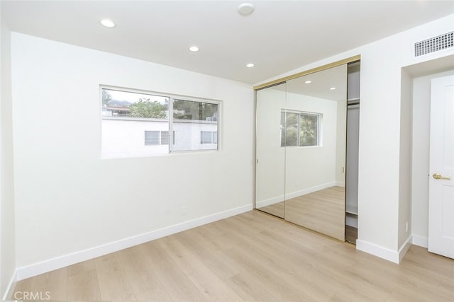 unfurnished bedroom featuring a closet, recessed lighting, and light wood finished floors