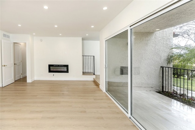 bathroom with visible vents, baseboards, recessed lighting, wood finished floors, and a glass covered fireplace