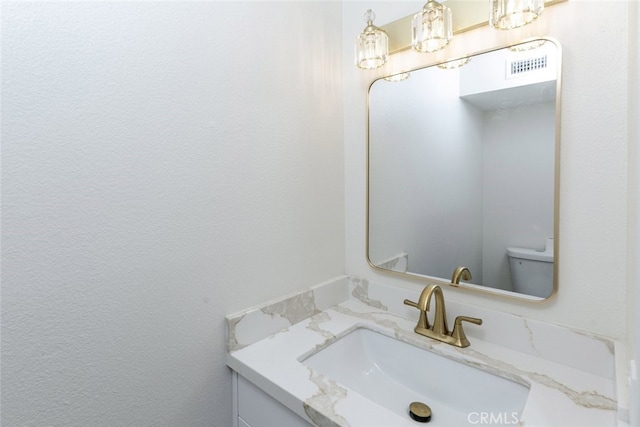 bathroom with visible vents, toilet, and vanity