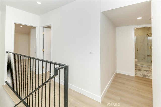 hallway with recessed lighting, baseboards, an upstairs landing, and light wood-style flooring