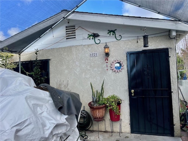 view of exterior entry featuring stucco siding