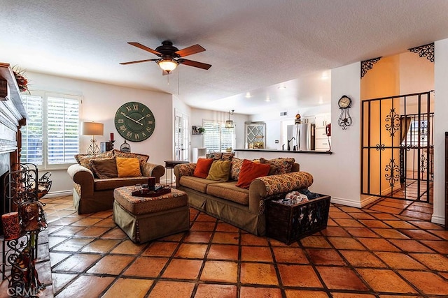 23461 Darcy Ln, Newhall, CA 91321 - living room with a ceiling fan, a fireplace with raised hearth, a textured ceiling, and baseboards