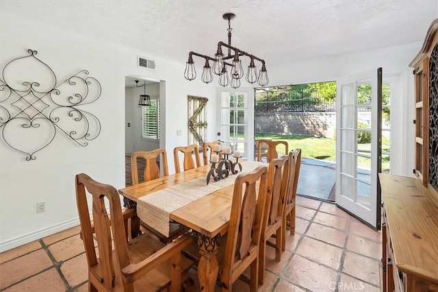23461 Darcy Ln, Newhall, CA 91321 - dining space featuring a chandelier, plenty of natural light, a textured ceiling, and stone tile floors