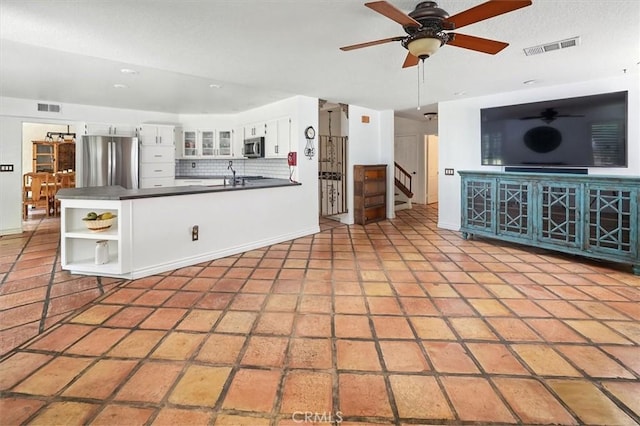 23461 Darcy Ln, Newhall, CA 91321 - kitchen with appliances with stainless steel finishes, dark countertops, open shelves, white cabinets, and a peninsula