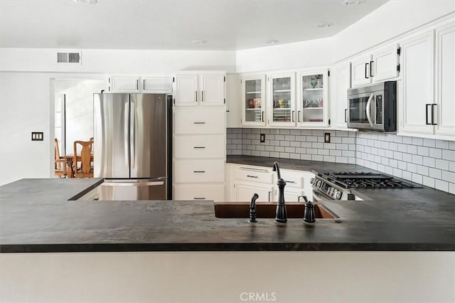 23461 Darcy Ln, Newhall, CA 91321 - kitchen featuring stainless steel appliances, dark countertops, glass insert cabinets, backsplash, and white cabinets