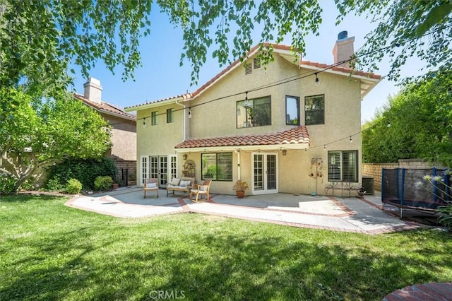 23461 Darcy Ln, Newhall, CA 91321 - back of house featuring french doors, a trampoline, stucco siding, and a patio area