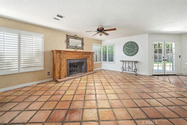 23461 Darcy Ln, Newhall, CA 91321 - unfurnished living room with a fireplace with raised hearth, a ceiling fan, healthy amount of natural light, a textured ceiling, and french doors