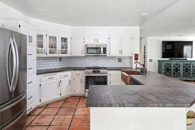 23461 Darcy Ln, Newhall, CA 91321 - kitchen with stainless steel appliances, dark countertops, tasteful backsplash, and white cabinetry