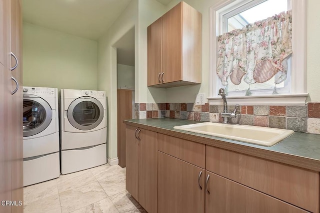 clothes washing area featuring a sink, cabinet space, and washing machine and dryer