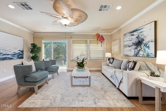 living area with visible vents, wood finished floors, and ornamental molding