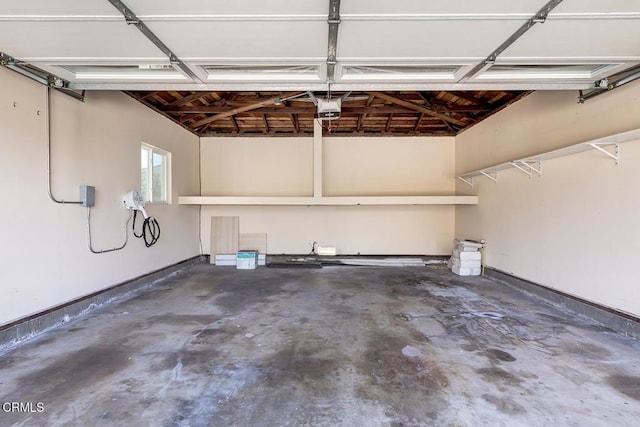 garage featuring a garage door opener and baseboards