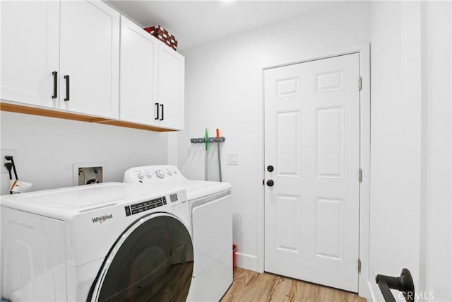 laundry area with cabinet space, light wood-style floors, and washing machine and clothes dryer