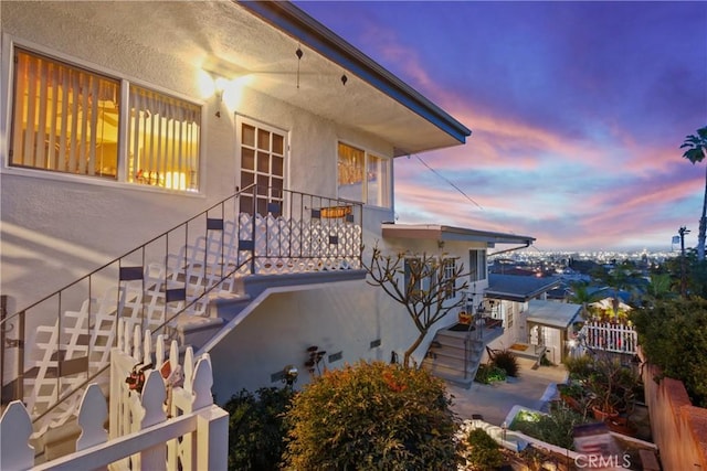 property exterior at dusk featuring stucco siding