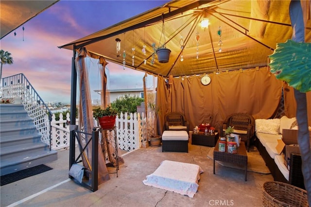 view of patio / terrace featuring a gazebo, an outdoor hangout area, stairs, and fence