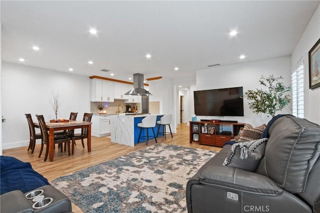 living area with recessed lighting, visible vents, baseboards, and light wood-style floors