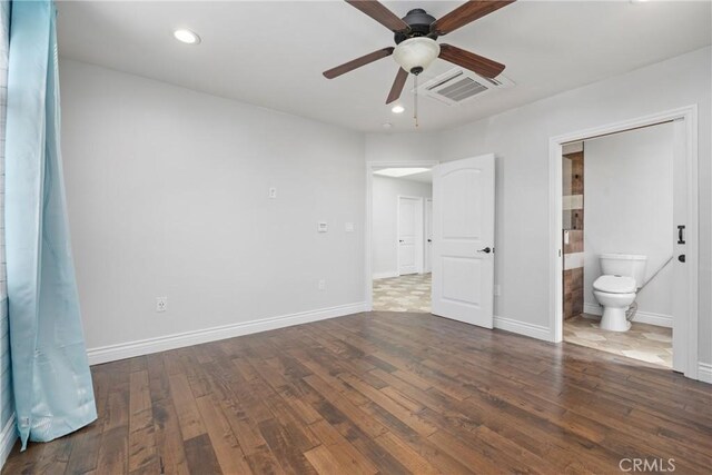 unfurnished bedroom featuring visible vents, hardwood / wood-style flooring, recessed lighting, connected bathroom, and baseboards