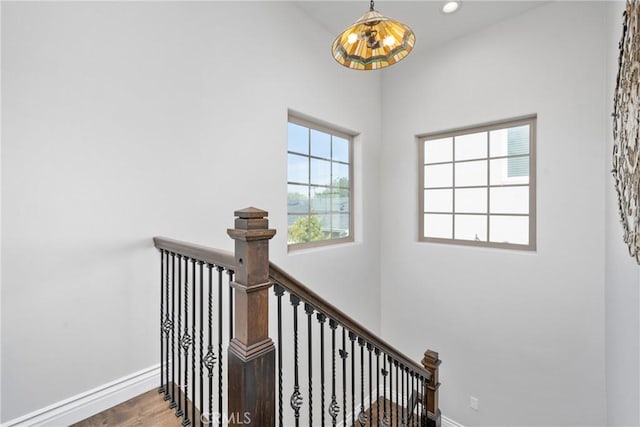 staircase with recessed lighting, baseboards, and wood finished floors