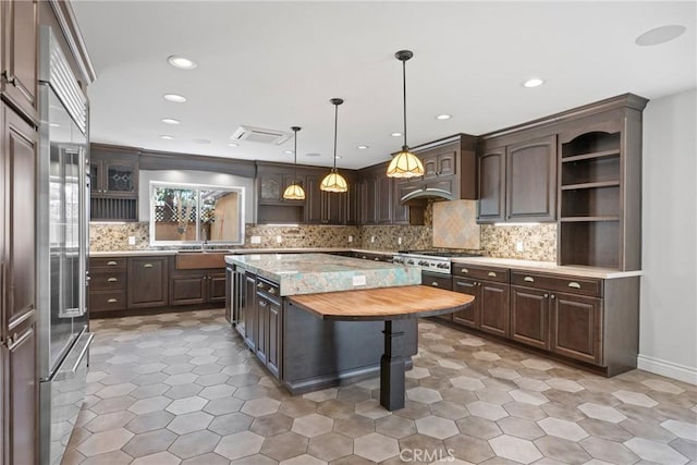 kitchen featuring open shelves, decorative backsplash, dark brown cabinetry, and appliances with stainless steel finishes