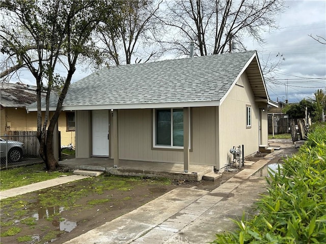 view of front of house with fence and a shingled roof