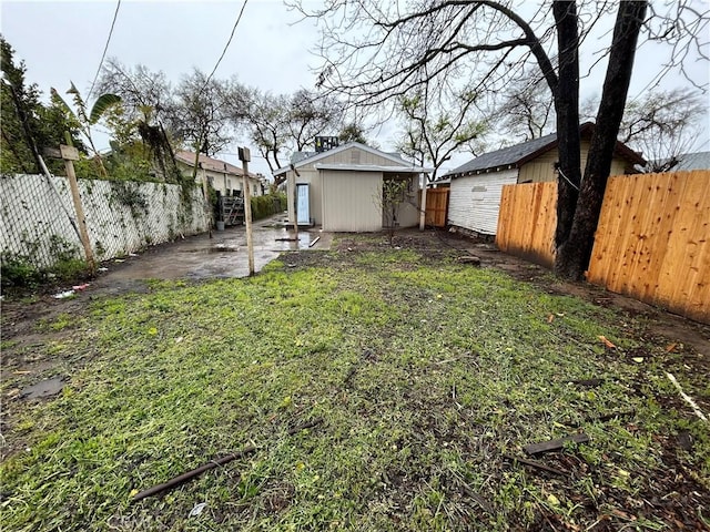 view of yard with a patio, a fenced backyard, and an outdoor structure