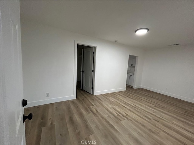 empty room featuring light wood-style flooring and baseboards