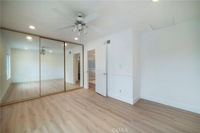 unfurnished bedroom with wood finished floors, visible vents, baseboards, recessed lighting, and a closet