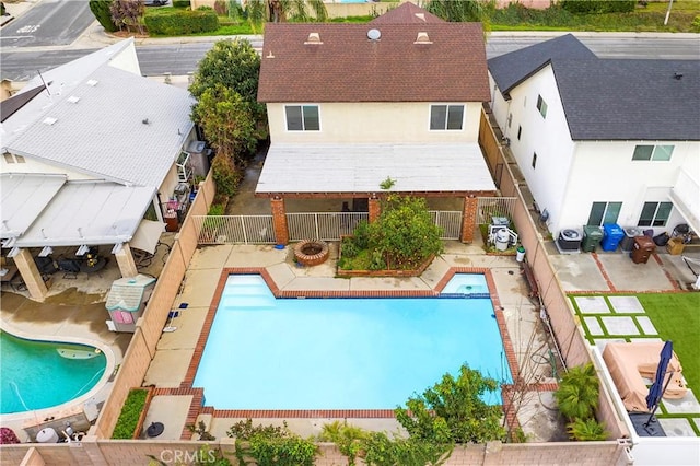 view of swimming pool featuring a patio area, cooling unit, a fenced backyard, and a pool with connected hot tub