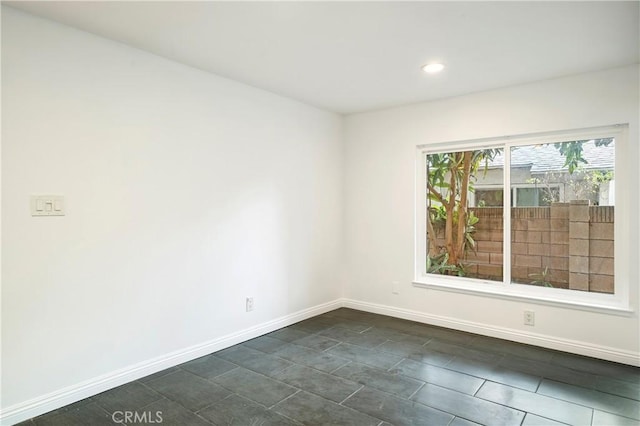 unfurnished room with recessed lighting and baseboards