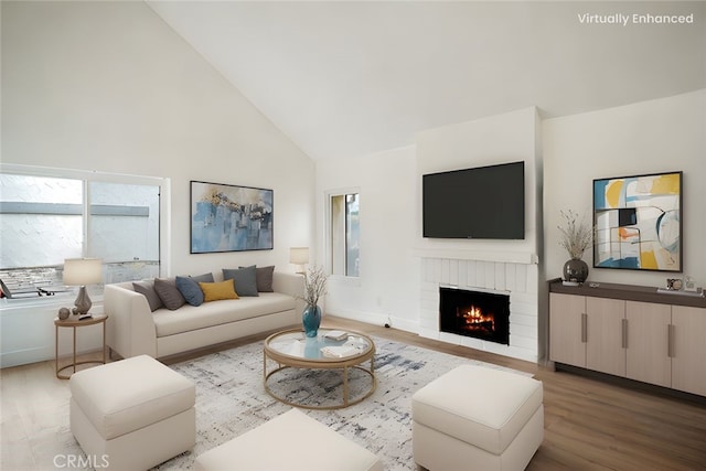 living room with a brick fireplace, high vaulted ceiling, and wood finished floors