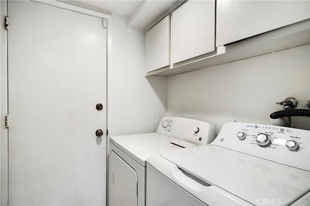 clothes washing area with cabinet space and washer and dryer