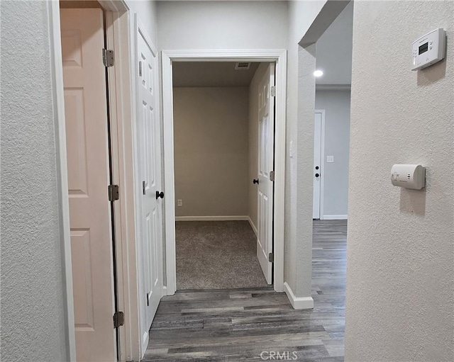 hall with baseboards, dark wood-style flooring, and a textured wall