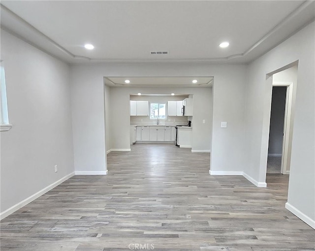 unfurnished living room with recessed lighting, visible vents, baseboards, and light wood finished floors