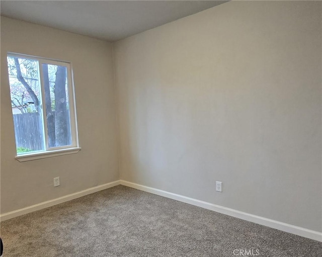 empty room featuring baseboards, carpet, and a healthy amount of sunlight