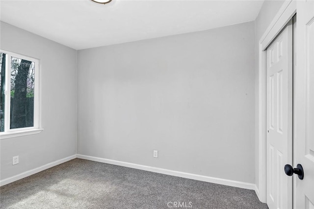 unfurnished bedroom with carpet flooring, baseboards, and a closet