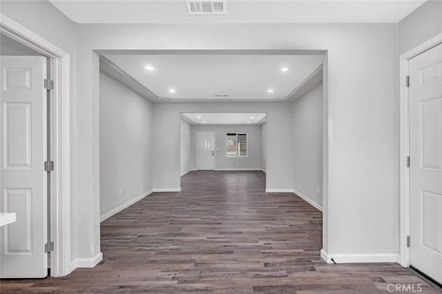 corridor with baseboards, visible vents, recessed lighting, and wood finished floors